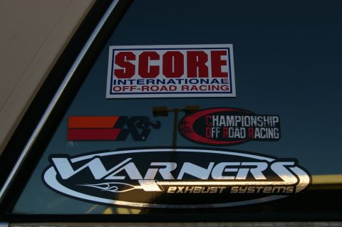 1986 Ford Bronco - Multiple off-road racing and exhaust system stickers are affixed to a vehicle's window.