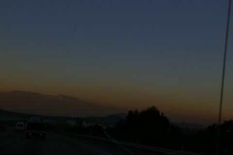 1986 Ford Bronco - Driving on a highway during sunset with mountains visible on the horizon.