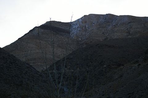 1986 Ford Bronco - A desolate mountain landscape with sparse vegetation and a hint of snow on the peaks.