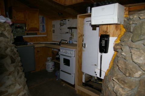 1986 Ford Bronco - A view inside a room with basic amenities including a stove, refrigerator, and telephone.