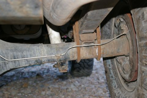 1986 Ford Bronco - Close-up view of the rear axle and suspension system on a 1986 Ford Bronco, showing leaf springs and brake components.