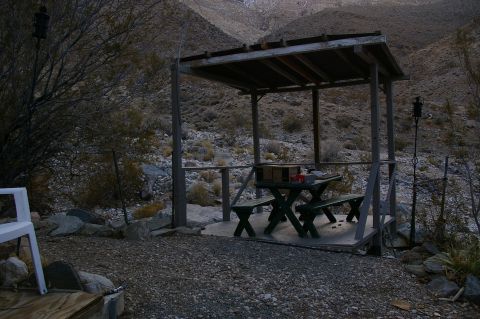 1986 Ford Bronco - A covered picnic area sits in a rocky, desert landscape with mountains in the background.