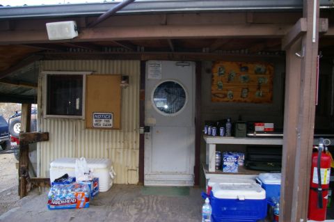 1986 Ford Bronco - Exterior view of a building with various items stored outside, including coolers and beverages.
