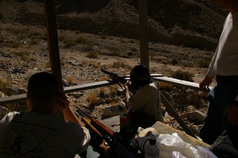 1986 Ford Bronco - Three individuals are at an outdoor shooting range, with two aiming rifles at a target.