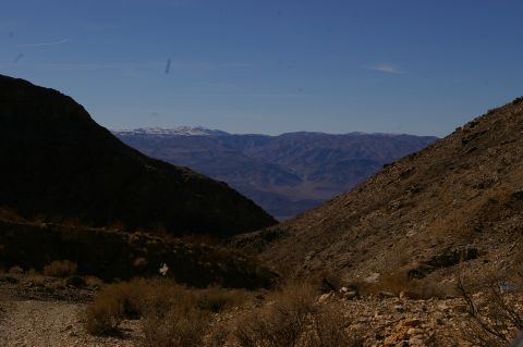 1986 Ford Bronco - A vast mountain vista unfolds under a clear blue sky, framed by the slopes of a desert canyon.