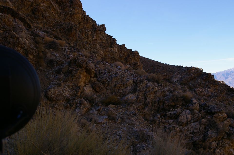 Black tire and rocky hillside under a clear blue sky