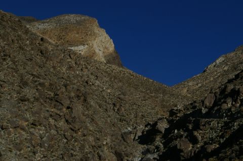 1986 Ford Bronco - A vast, rocky desert landscape with sparse vegetation and a deep blue sky.