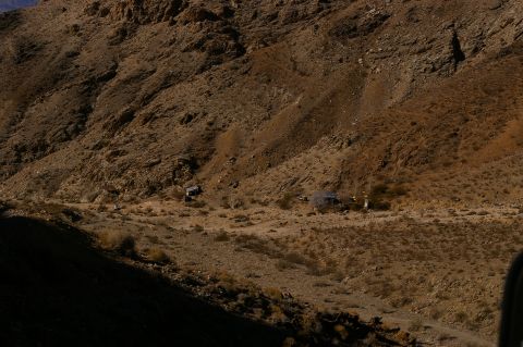 1986 Ford Bronco - A wide shot of a desert landscape mountains and small structures.
