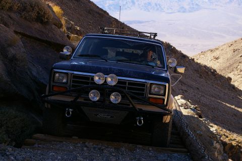 1986 Ford Bronco - A Ford Bronco navigates a challenging off-road trail, demonstrating its capability in terrain.