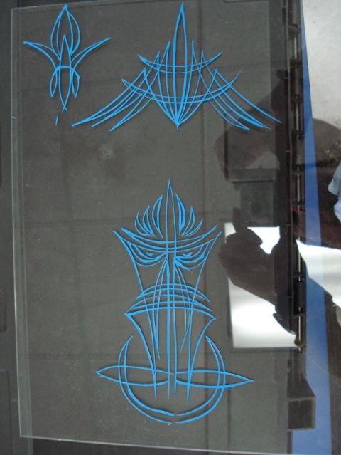 1979 Chevrolet C/K Pickup - Blue pinstripe art is applied to a clear glass panel, possibly for a vehicle customization project.