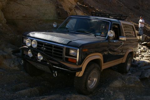 1986 Ford Bronco - A Ford Bronco navigates a rocky, off-road path in a desert canyon.