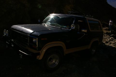 1986 Ford Bronco - 1986 Ford Bronco on a rocky trail, with a person standing in the background.