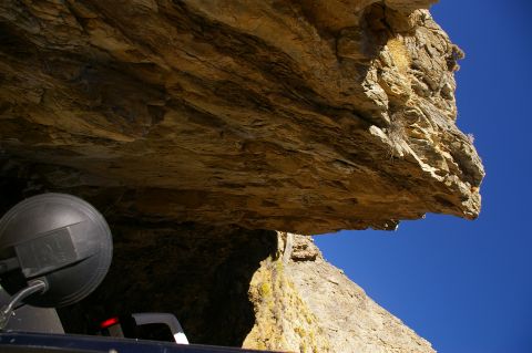 1986 Ford Bronco - View from inside a vehicle looking up at a rock overhang on a clear day.