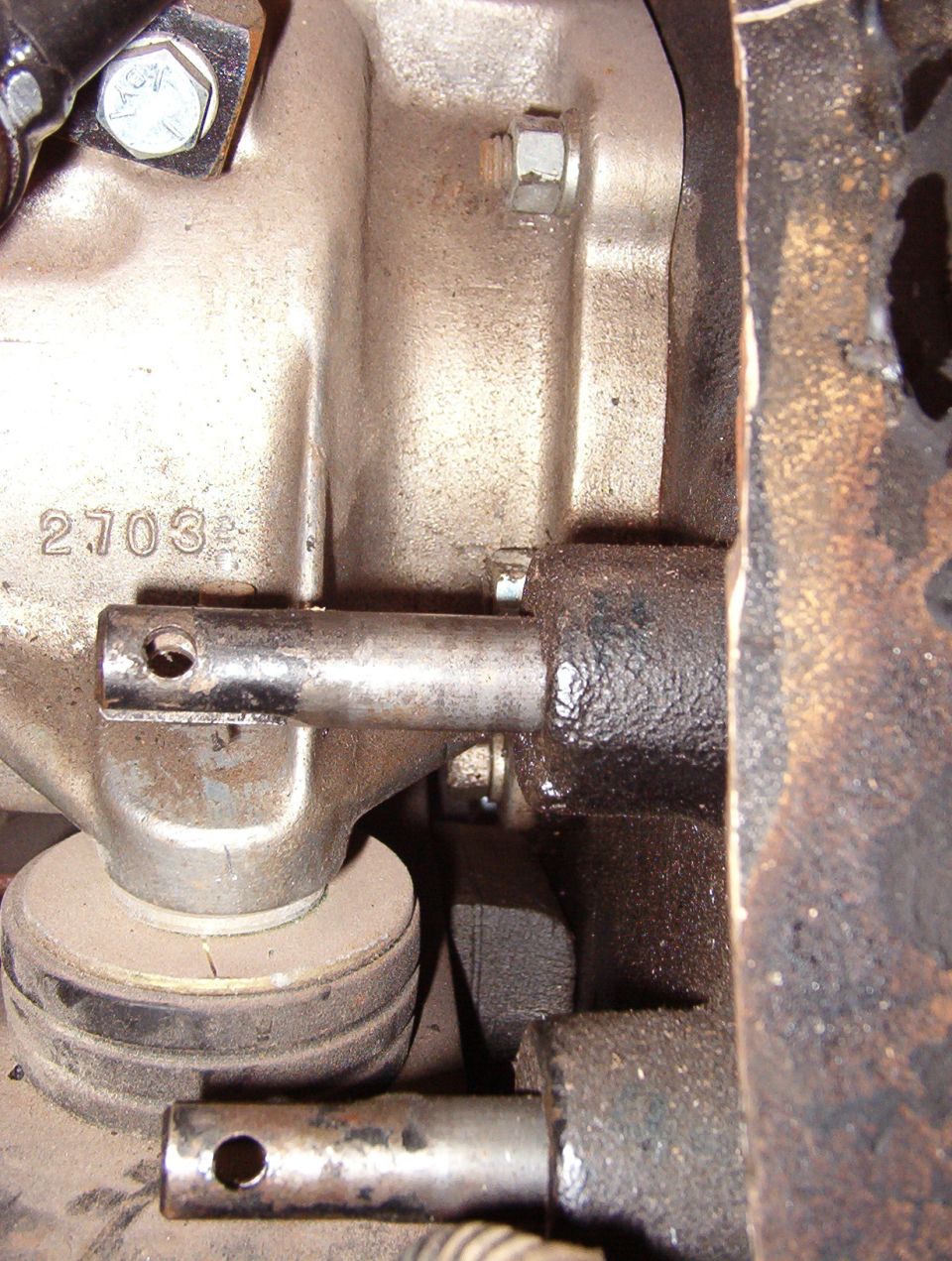 With the rubber bumper installed at the back of the crossmember, it's impossible to get to the lower L nut.  And it takes a 4-way wrench to get to the middle L (almost visible above the upper shift rail).

The adapter required clearancing of the crossmember in several spots, and 1/2" of washers on each trans mount.  See the NEXT pic...