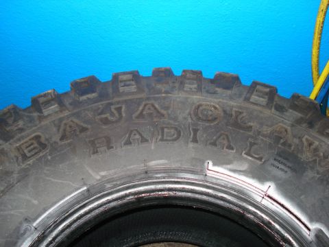 1994 Ford Bronco - A close-up view of a tire shows the 'Baja Radial' branding on its sidewall.