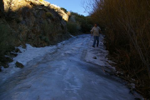 1986 Ford Bronco - A person walks on a slippery, icy dirt road in a natural setting.