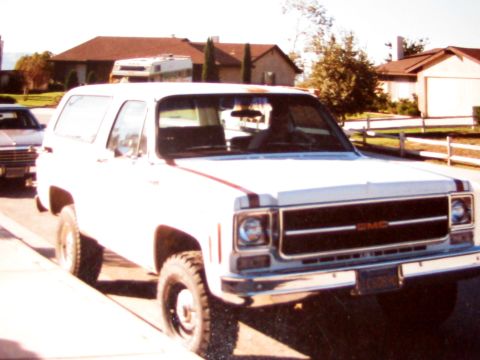 1996 Ford Bronco - This GMC Jimmy is parked on a residential street with houses in the background.