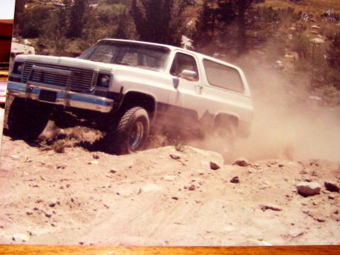 1996 Ford Bronco - This two-tone SUV navigates a dusty, rocky trail, demonstrating its off-road capabilities.