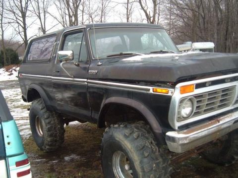 1979 Ford Bronco - This black 1979 Ford Bronco is equipped with large off-road tires, suggesting it is ready for terrain.