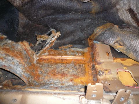1975 Ford Ranchero - Severe rust damage is visible on the floor pan and structural components of the vehicle's interior.