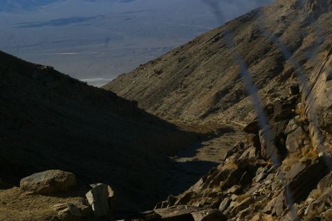 1986 Ford Bronco - A vast, arid landscape unfolds, with terrain dominating the foreground and a wide valley stretching towards distant, hazy mountains.