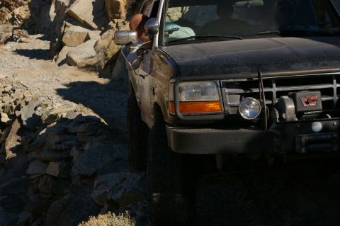 1986 Ford Bronco - 1986 Ford Bronco navigating a challenging rocky path.