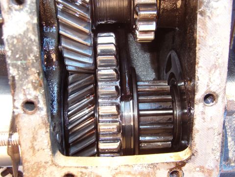 1975 Ford Bronco - The output gear (lower R) is slid forward on the output shaft to engage the splines of the input gear, providing hi-range.