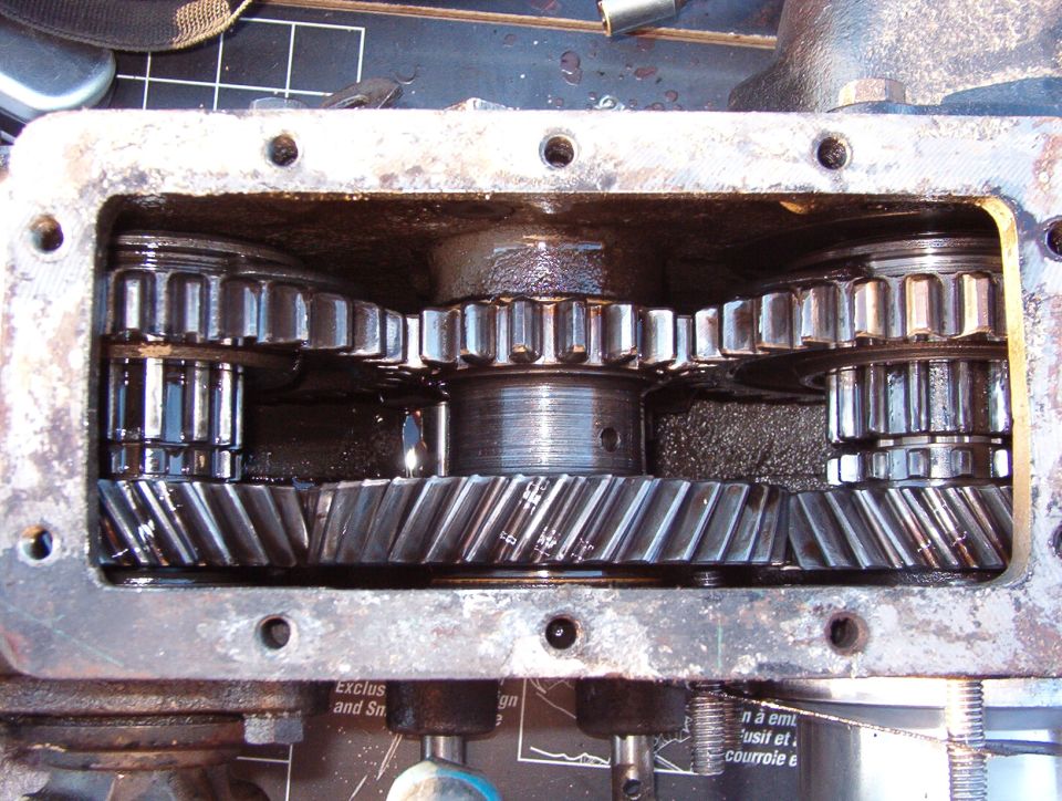 With both output gears slid rearward, the t-case is in 4L.

The Aluminum sleeve & stub shaft at the lower R are for the Advance Adapters kit for the AOD.  Removing that shaft from the t-case allows about a dozen roller bearings to fall loose into & out of the t-case.  Finding & re-installing them is a challenge.