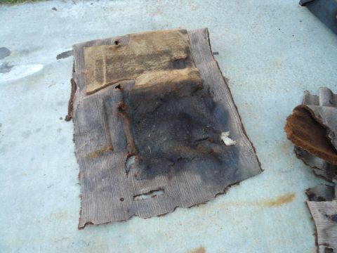 1975 Ford Ranchero - These old, damaged car floor mats appear to be removed from a vehicle for replacement.