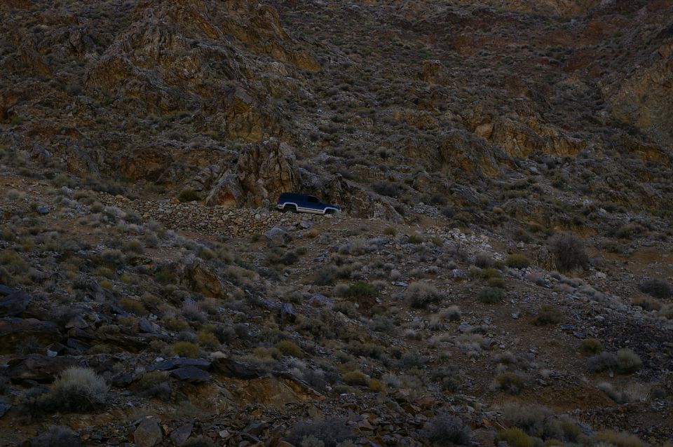 Dark blue 1986 Ford Bronco parked on a rocky, barren hillside