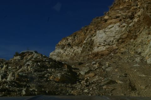 1986 Ford Bronco - A white SUV is visible on a rocky hill, with a steep cliff face to the right.