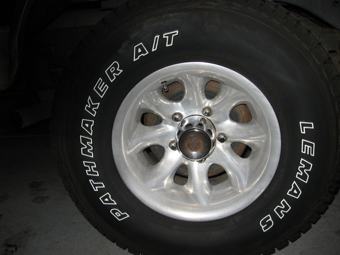 Close-up of a tire with 'PATHMAKER A/T' and 'LEMANS' text, on a silver alloy wheel
