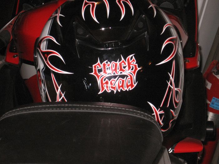 Black motorcycle helmet with red and white flames and 'crack head' text