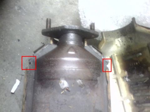 1993 Ford Probe - Close-up view of a catalytic converter part, with damage highlighted by red squares.