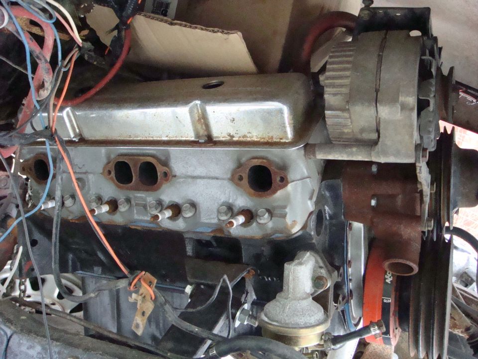 Engine with chrome valve covers, spark plugs, and wiring. An alternator is visible on the right