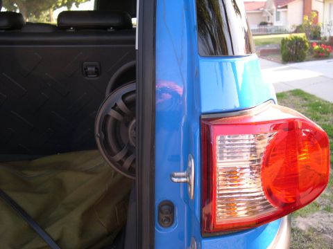 2007 Toyota FJ Cruiser - The rear door and taillight of a blue 2007 Toyota FJ Cruiser are visible, with a speaker mounted inside the cargo area.