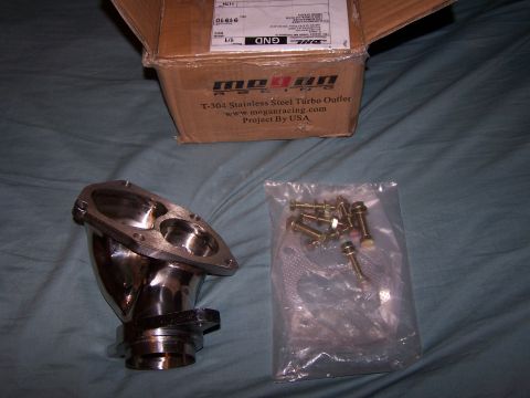 1995 Ford Probe - A turbo outlet part and a bag of bolts are laid out next to an open box from Megan Racing.