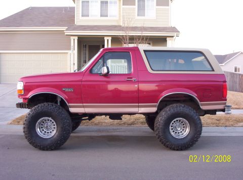 1995 Ford Bronco - This lifted 1995 Ford Bronco features a two-tone paint scheme with a red body and tan removable top.
