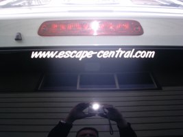 2006 Ford Escape - The rear of a vehicle is shown, with a website address displayed on the lower part of the liftgate.