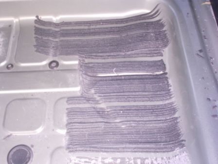 2006 Ford Escape - A stack of cut metal sheets is visible inside a metal container, with a watermark from Supermotors.net.