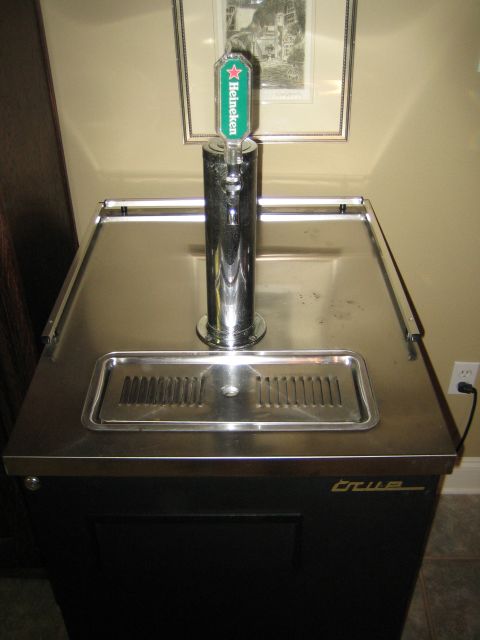 1995 Ford Bronco - A kegerator with a Heineken tap is shown in a room with framed art on the wall.