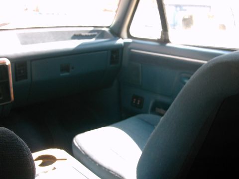 1987 Ford Bronco - Interior view of a vehicle's dashboard, door panel, and seats, showing a blue color scheme.