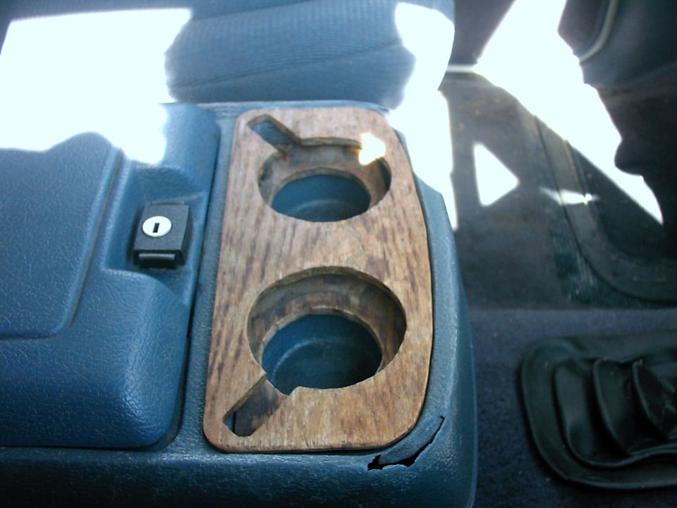Interior shot of a vehicle's center console with two cupholders and a lock button