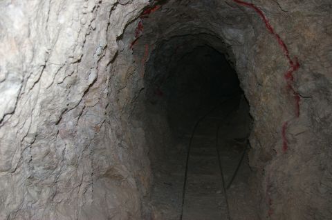 1986 Ford Bronco - Interior of a mine tunnel showing tracks and rough rock walls, with red markings.