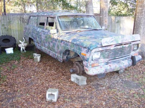 2004 Jeep TJ - This Jeep Wagoneer is missing its wheels and is covered in a camouflage paint scheme.