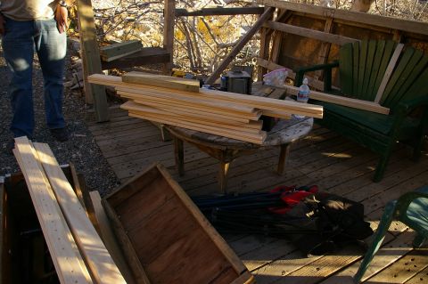 1986 Ford Bronco - A scene depicting a construction area with stacks of lumber, outdoor furniture, and a person standing on a wooden deck.