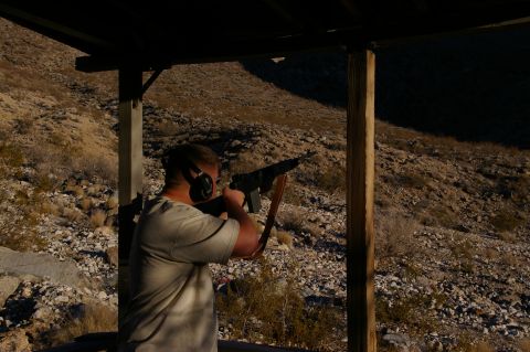 1986 Ford Bronco - A shooter takes aim at a distant target from a covered position at an outdoor range.