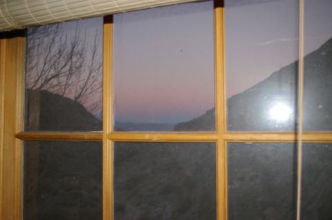 1986 Ford Bronco - A tranquil landscape unfolds outside the window as twilight paints the sky with soft hues.