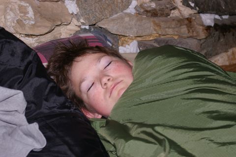 1986 Ford Bronco - Child sleeping soundly in a sleeping bag, tucked in for the night.