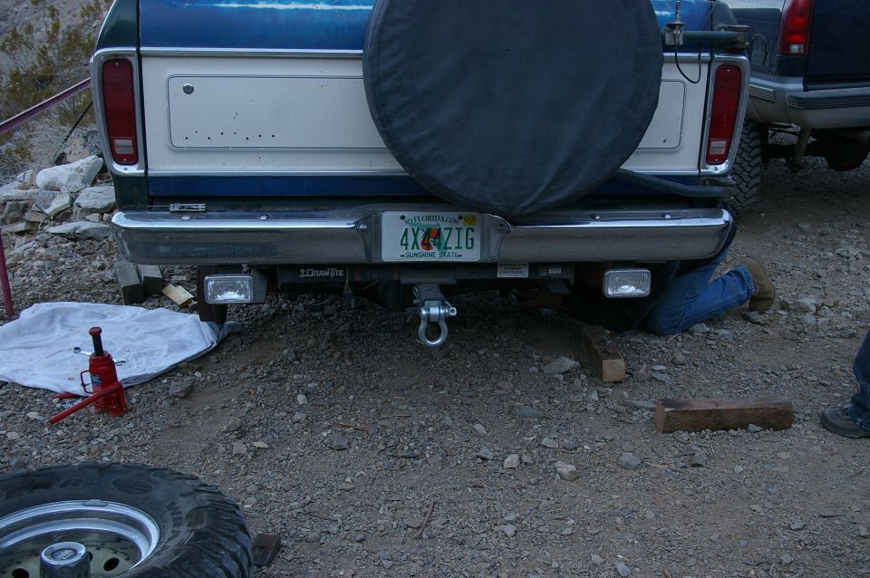 Blue and white Ford truck rear bumper with a spare tire cover, tow hitch, and Florida license plate
